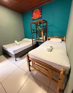 two beds in a room with blue walls at Madroño Hostel in León +24 photos