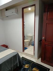 a room with a bathroom with a toilet and a door at Hostal Cigarra in Panama City +41 photos