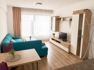 a living room with a blue couch and a tv at Apartment Centrum Orion in Dubnica nad Váhom