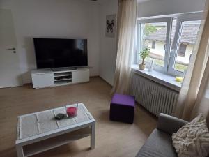 a living room with a flat screen tv and a table at Ferienwohnung Nele in Heimbach