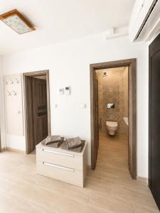 a white bathroom with a toilet and a sink at Apartment Centrum Orion in Dubnica nad Váhom