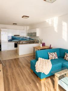 a living room with a blue couch and a kitchen at Apartment Centrum Orion in Dubnica nad Váhom
