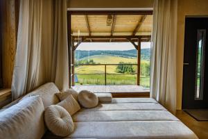a living room with a couch and a large window at Kamienny Horyzont in Bereżnica Wyżna