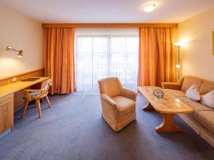 a living room with a couch and a table at Appartementhaus Holmernhof I in Bad Füssing