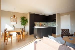 a living room and kitchen with a table and chairs at Modern 3 bedroom apartment - 4 minute walk from metro - top floor baclony view in Oslo