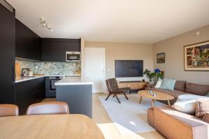 a living room with a couch and a table at Modern 3 bedroom apartment - 4 minute walk from metro - top floor baclony view in Oslo