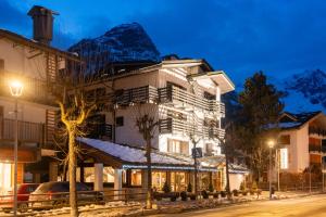 a building with a snow covered mountain in the background at Hotel Les Jumeaux Courmayeur in Courmayeur