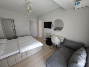 a bedroom with a bed and a desk and a couch at Struga Lake Suites in Struga