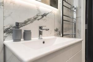 a white bathroom sink with two cups on it at Family & Group House | 3 Baths | Sleeps 12 in Banbury +49 photos