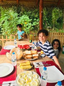 a group of children sitting at a table with food at Jungle Lake View Cabana in Udawalawe +75 photos