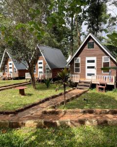 a group of cottages with benches and a house at Riverside chania resort in Nyeri