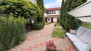 eine Terrasse mit einer Couch und einigen Pflanzen und ein Haus in der Unterkunft Hotel Veagles in Narva-Jõesuu