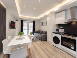 a kitchen and living room with a white table and chairs at Family & Group House | 3 Baths | Sleeps 12 in Banbury
