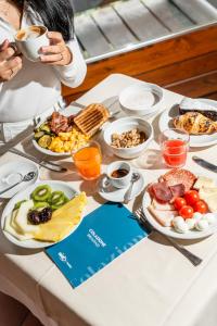 a table with plates of food on a table at Hotel Les Jumeaux Courmayeur in Courmayeur