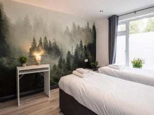 a bedroom with two beds and a painting of a forest at Family & Group House | 3 Baths | Sleeps 12 in Banbury