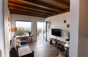 a living room with a couch and a tv at Tabaiba Suites Lanzarote - Macaronesia Homes in La Asomada