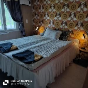 a bedroom with a bed with blue clothes on it at Retro House in Savonlinna