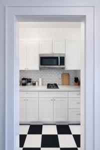 a kitchen with white cabinets and a black and white checkered floor at Downtown High Falls Studio Apt, Kitchen, TV in Rochester