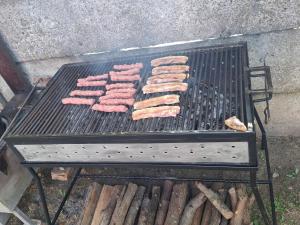 a bunch of meat cooking on a grill at Casa Szabo in Vaţa de Jos +17 photos