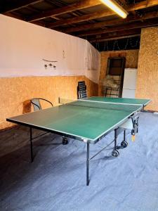 a green ping pong table in a room with chairs at Altes Landhaus in Behrendorf