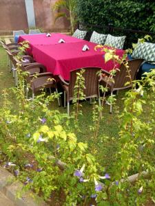 a table and chairs with a pink table cloth at SolBlu Cottages in Kira