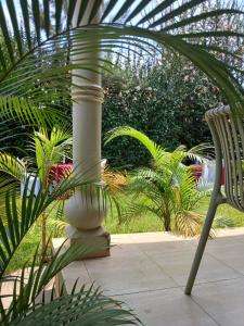 a white column and a chair in a garden at SolBlu Cottages in Kira