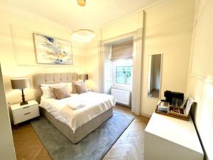 a bedroom with a white bed and a window at 'Maisie' in ApartNest Auchterarder in Auchterarder