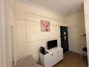 a living room with a television on a white cabinet at 'Maisie' in ApartNest Auchterarder in Auchterarder