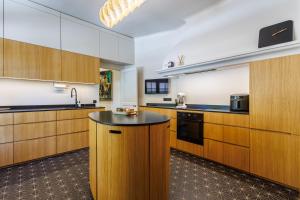 a kitchen with wooden cabinets and a black counter top at Villa du Val - Welkeys in Aix-en-Provence
