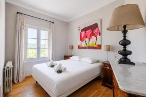 a bedroom with a white bed and a window at Villa du Val - Welkeys in Aix-en-Provence