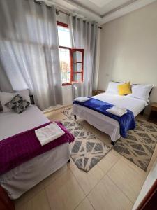 a bedroom with two beds and a window at Hostel dallas Warzazate in Ouarzazate