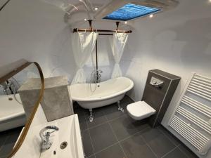 a bathroom with a sink and a tub and a toilet at Tin Can Town Oirschot in Oirschot +205 photos