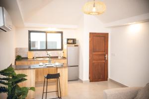 a kitchen with a sink and a refrigerator at Résidence Daana in Komé