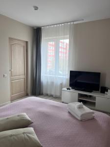 a bedroom with a large bed and a television at Straumes apartamenti in Valmiera