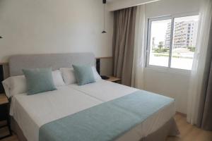 a bedroom with a large bed with a window at AR Roca Esmeralda & SPA Hotel in Calpe