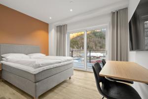 a hotel room with a bed and a table with chairs at Skudeløken Apartment Hotel in Førde