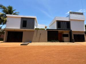 a house with a palm tree in front of it at Résidence Daana in Komé