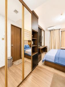 a bedroom with a bed and a large mirror at Transpark Cibubur by 21room in Kalimanggis +6 photos