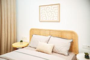 a bed with white pillows and a picture on the wall at Résidence Daana in Komé