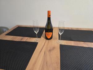 a bottle of wine sitting on a wooden table with two glasses at Apartment Linde in Bubesheim