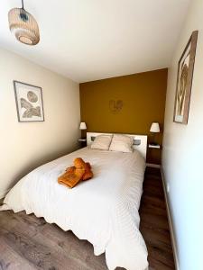 a teddy bear sitting on a bed in a bedroom at La Villa d'Aix - Entre lacs et montagne - Jacuzzi in Saint-Ours