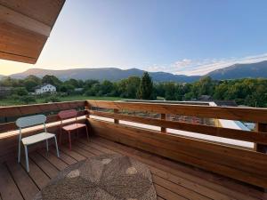 a balcony with two chairs and a table and a view at La Villa d'Aix - Entre lacs et montagne - Jacuzzi in Saint-Ours