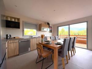 a kitchen and dining room with a table and chairs at La Villa d'Aix - Entre lacs et montagne - Jacuzzi in Saint-Ours