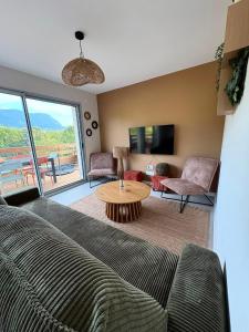 a living room with a couch and a table at La Villa d'Aix - Entre lacs et montagne - Jacuzzi in Saint-Ours