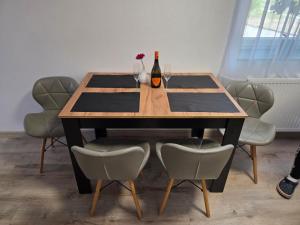 a dining room table with a bottle of wine and chairs at Apartment Linde in Bubesheim