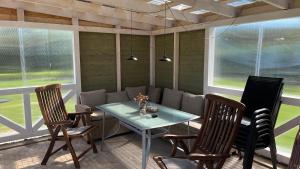 a dining room with a table and chairs and windows at Peipsi Village Sofia in Kasepää +14 photos