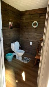 a bathroom with a toilet in a room with wooden walls at Peipsi Village Sofia in Kasepää