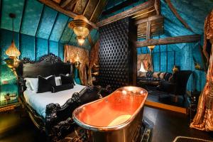 a bedroom with a bed and a tub and a couch at Crazy Bear Beaconsfield in Beaconsfield