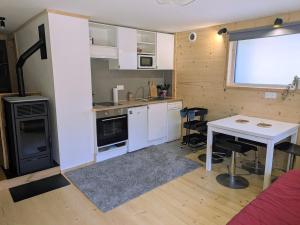 a small kitchen with a white table and a table and chairs at Nice chaleett in mountains in Saint-Martin-de-Belleville