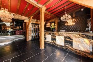 a dining room with a bar with chandeliers at Crazy Bear Beaconsfield in Beaconsfield